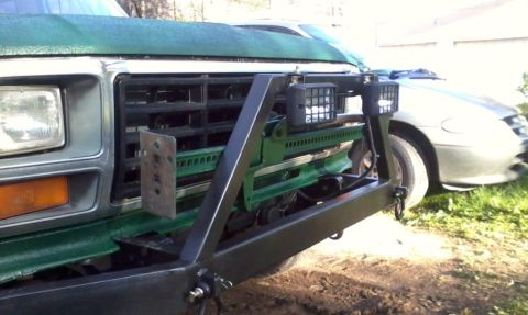 1986 Ford Bronco - Front view of a green truck with aftermarket bumper and auxiliary lights, parked outdoors.
