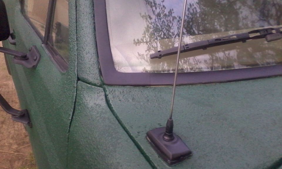 Green textured vehicle door and windshield frame with antenna base