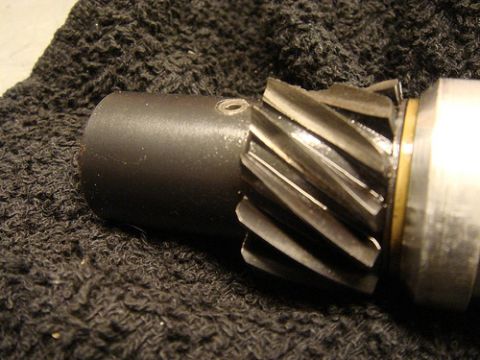 1990 Ford Bronco - Close-up of a damaged metal gear with helical teeth, possibly from a vehicle's transmission or distributor.