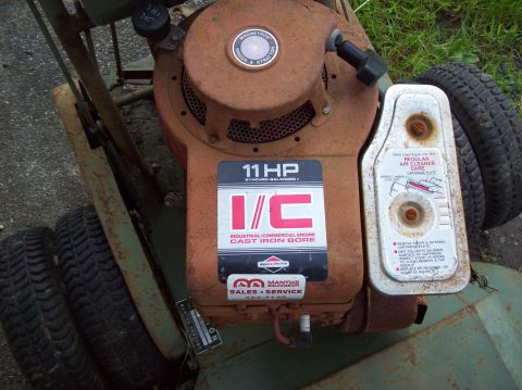 1995 Ford Bronco - Close-up of a Briggs & Stratton 11 HP engine label on a vintage lawnmower, showing signs of rust and wear.