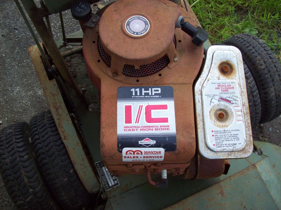 Rusty Briggs & Stratton 11 HP I/C engine on a green equipment frame, top-down view