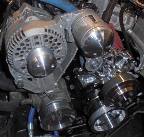 1990 Ford Bronco - Close-up view of engine pulleys and alternator assembly with blue hoses.