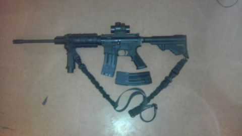 2000 Mercury Grand Marquis - An AR-15 style rifle and its accessories are laid out on a textured surface.