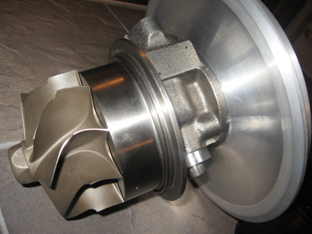 Turbocharger turbine wheel with cast iron housing