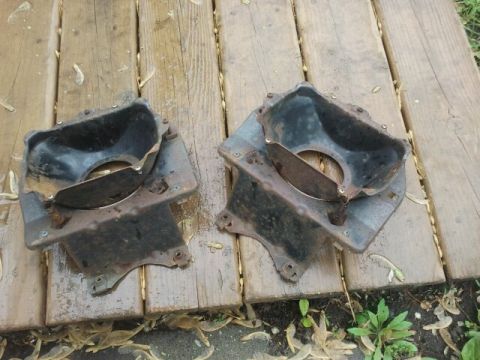 1979 Ford Bronco - Two weathered metal components are displayed on a wooden surface, suggesting they are vehicle parts.