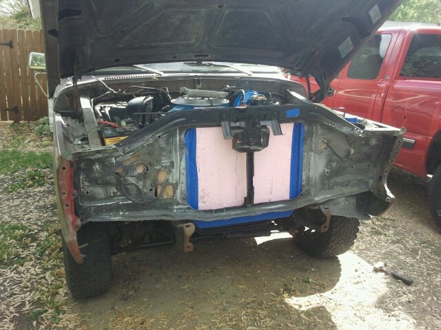 front of truck with hood open, radiator removed, and engine exposed