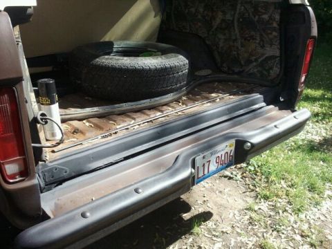 1979 Ford Bronco - The rear cargo area of a 1979 Ford Bronco shows a spare tire and an Illinois license plate.