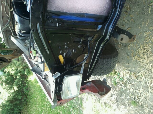 Red and black vehicle frame with exposed engine components and a headlight assembly
