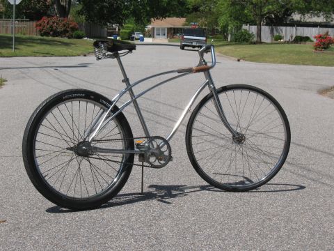 1994 Ford Bronco - A vintage-style bicycle with a chrome frame and black tires is parked on a residential street.