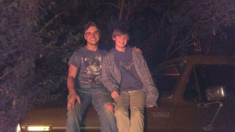 1979 Ford Bronco - Two young men pose on the hood of a vintage truck at night, with the Supermotors logo visible on the vehicle.