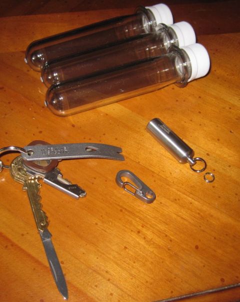 1990 Ford Bronco - A collection of items including test tubes and a keychain with tools is laid out on a wooden table.