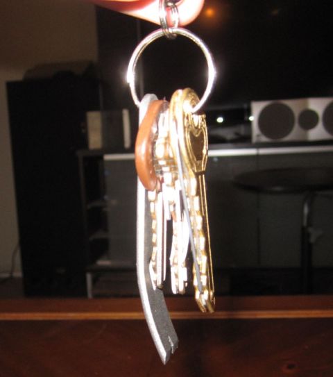 1990 Ford Bronco - A keychain holds a collection of keys, one of which is a decorative gold key with a heart-shaped top.