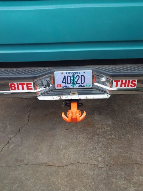 1993 Ford Bronco - The rear of a vehicle shows a license plate and two stickers on the bumper.