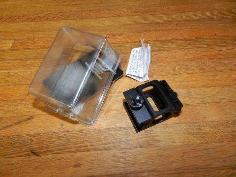 1996 Ford Bronco - A black metal automotive part is shown in its packaging alongside a document and a separate metal bracket on a wooden surface.