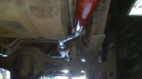 1978 Ford Bronco - Close-up of vehicle undercarriage, focusing on suspension components and a red shock absorber.