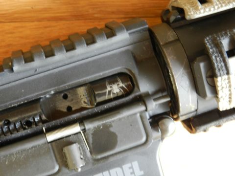 1996 Ford Bronco - A firearm's internal mechanism is visible, a spider graphic on the bolt carrier.