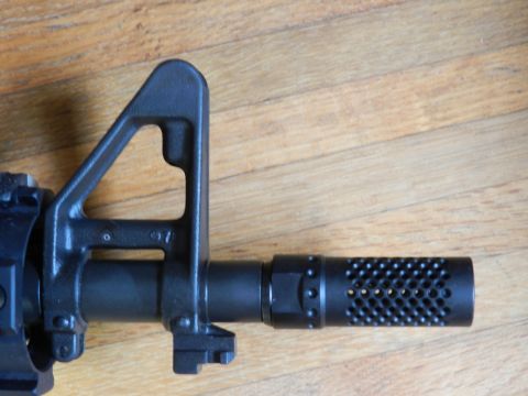 1996 Ford Bronco - Close-up view of a rifle's front sight post and a perforated muzzle brake.