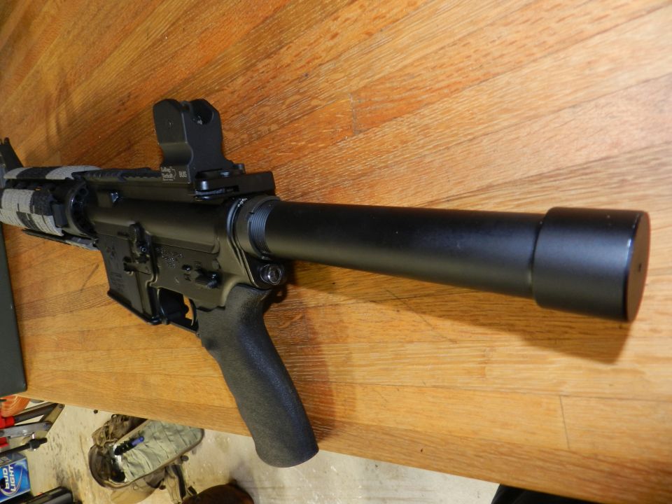 assault rifle with suppressor on wooden surface