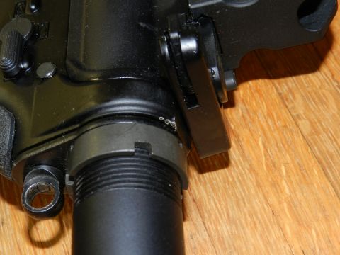 1996 Ford Bronco - Close-up view of a firearm receiver, showing mechanical components and a wooden background.