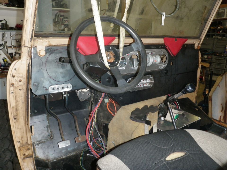 1961 International Scout 800 interior with black steering wheel, gauges, and tan seat