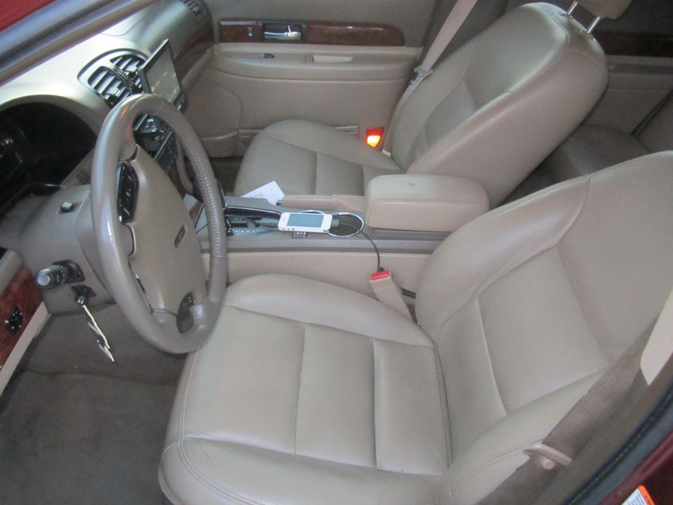 Tan leather interior of a 2002 Lincoln LS, showing the steering wheel, dashboard, and front seats