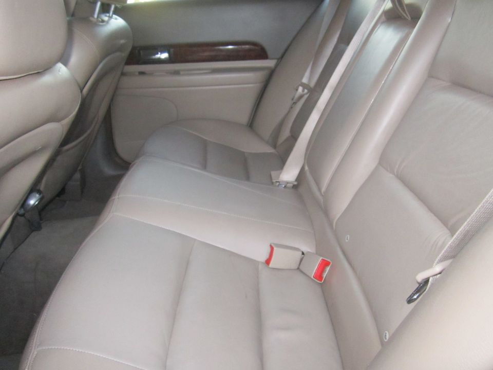 Rear leather seats with beige upholstery and seatbelts