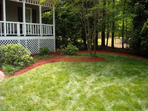 1979 Ford F-150 - A well-maintained front yard features a porch, manicured lawn, and surrounding trees.