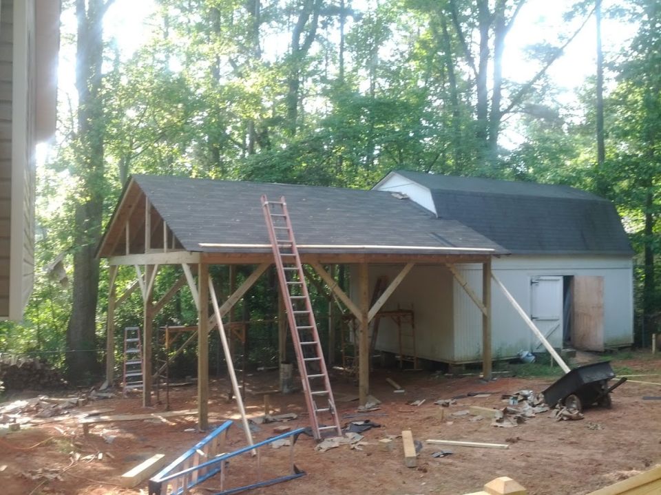 Construction site with unfinished carport, shed, and ladders