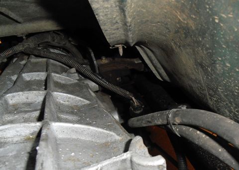 1990 Ford Bronco - Detail shot of a vehicle's transmission housing, showing associated wiring and hoses.