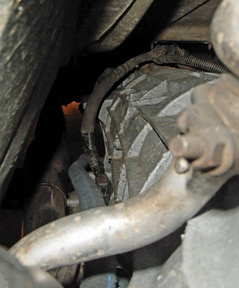 1990 Ford Bronco - Underside view of vehicle transmission and exhaust system components.