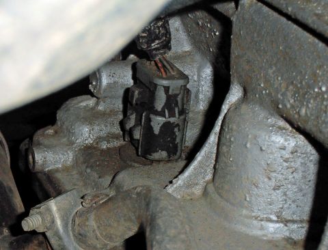 1990 Ford Bronco - Close-up view of an electrical connector on a vehicle's engine block.