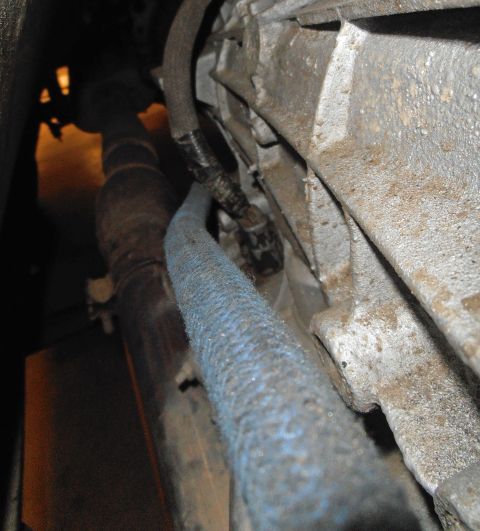 1990 Ford Bronco - Underside view of a vehicle's transmission and exhaust system, showing wiring and pipes.