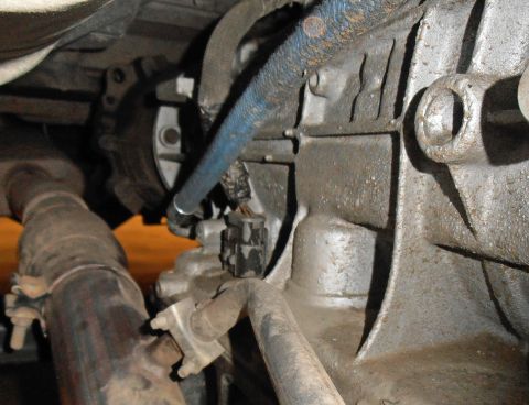1990 Ford Bronco - Close-up view of the transmission housing and exhaust system components.