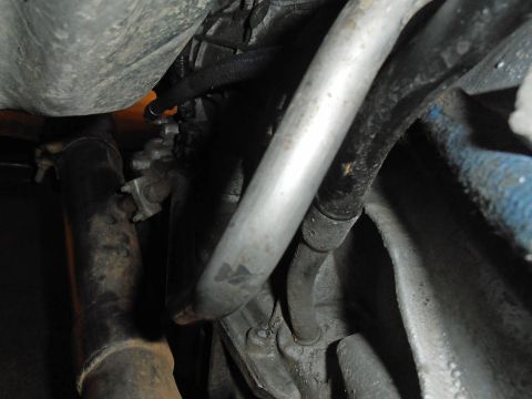 1990 Ford Bronco - Close-up view of a vehicle's undercarriage, showing various mechanical parts and exhaust system components.
