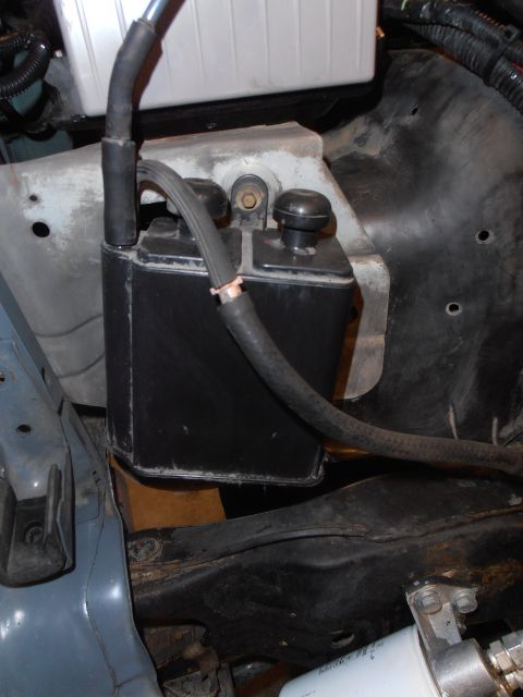 1990 Ford Bronco - A close-up view of a component within the engine bay, hoses and mounting hardware.
