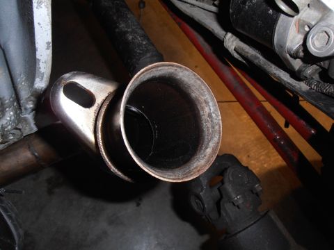 1990 Ford Bronco - Close-up view of a vehicle's exhaust pipe and a U-joint.