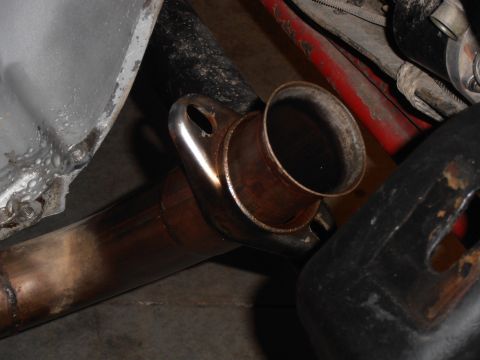 1990 Ford Bronco - Close-up view of an exhaust pipe flange, showing signs of rust and use.