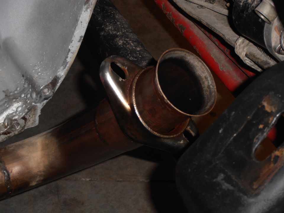 Exhaust pipe flange connection with visible rust and wear