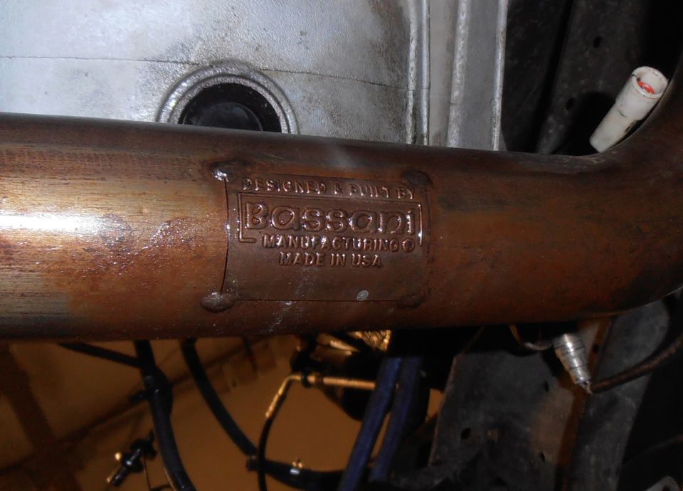 Exhaust pipe with Bossoni Manufacturing plate, made in USA, showing rust and wear