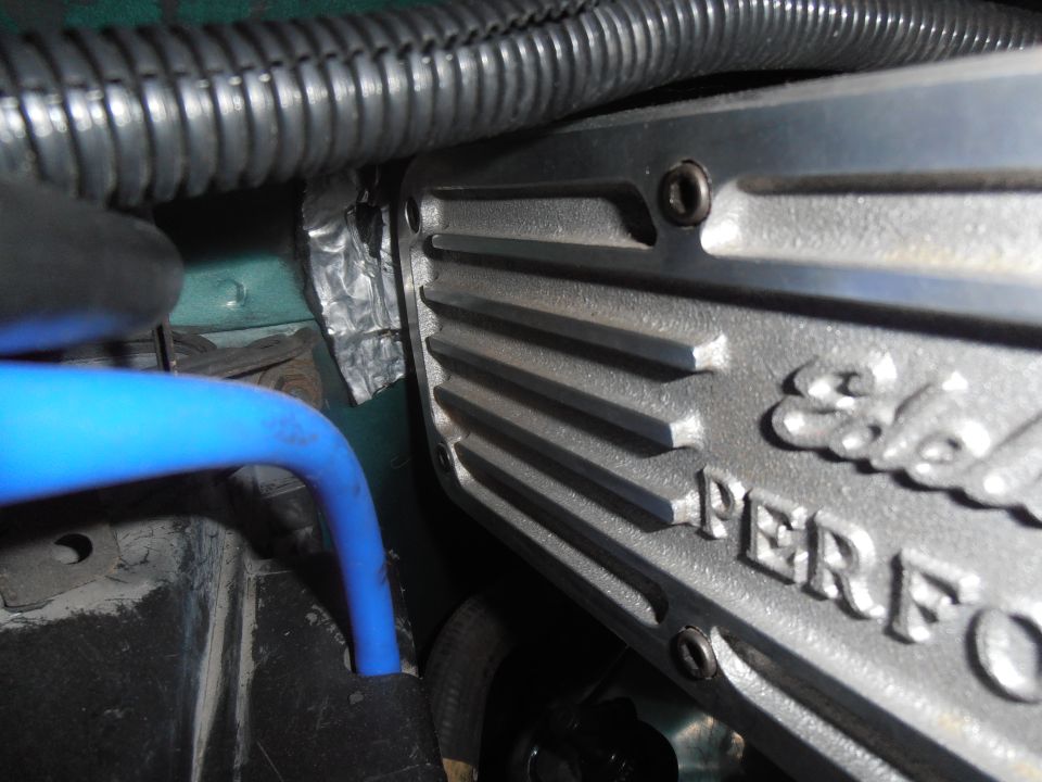 Close-up of Edelbrock Performance valve cover with blue hose