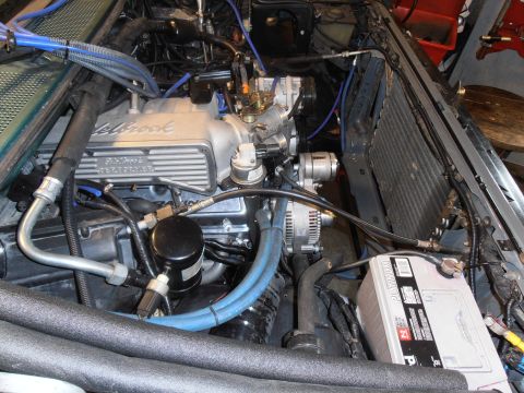 1990 Ford Bronco - Close-up of a V8 engine bay with various components visible, including the Edelbrock valve covers.