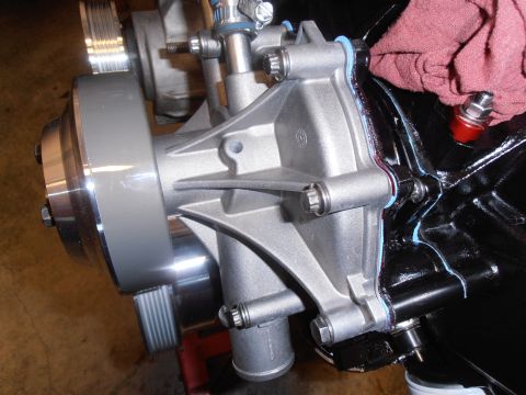 1990 Ford Bronco - Close-up of an engine water pump assembly with blue sealant visible.