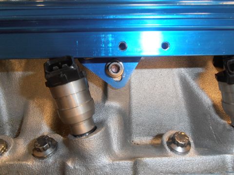 1990 Ford Bronco - Fuel injectors and fuel rail detail on an engine.