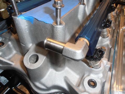 1990 Ford Bronco - Close-up view of fuel injectors and a blue fuel rail mounted on a silver intake manifold.