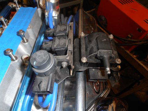 1990 Ford Bronco - Close-up view of engine ignition coils and associated wiring, with blue tape on a metal component.