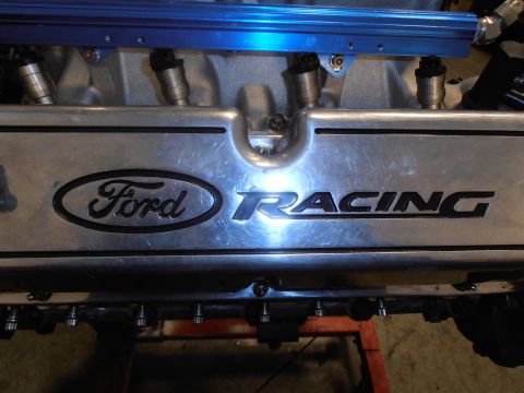 1990 Ford Bronco - Close-up of a Ford Racing engine component, likely a valve cover, with visible fuel injectors.
