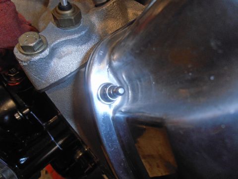 1990 Ford Bronco - Detail of a shiny engine component, possibly a valve cover or oil pan, with visible fasteners.