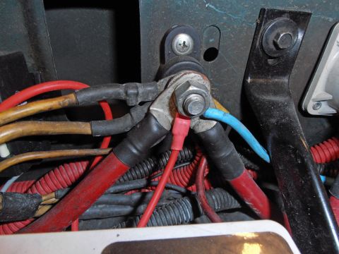 1990 Ford Bronco - Close-up view of a vehicle's electrical wiring and battery terminals.