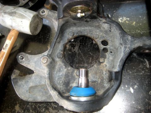 1996 Ford Bronco - A close-up view of a vehicle's suspension knuckle, showing a ball joint assembly and associated hardware.