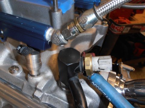 1990 Ford Bronco - Close-up view of engine components including a fuel injector and fuel rail.